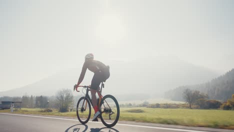 Ciclista-Masculino-Montando-Su-Bicicleta-De-Carretera-En-Las-Montañas-Eslovenas-Mientras-Brilla-El-Sol