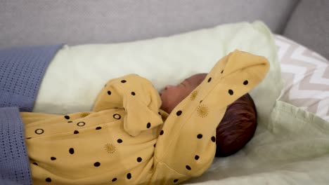A-precious-moment-of-a-1-week-old-newborn-baby-peacefully-sleeping-in-a-yellow-dotted-pajama,-epitomizing-the-serene-essence-of-newborns-and-infants
