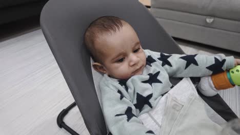 Adorable-4-month-old-baby-bouncer,-holding-onto-cloth