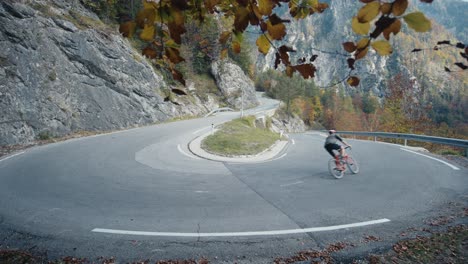 Ein-Fahrradfahrer,-Der-Auf-Dem-Hügel-In-Den-Bergen-In-Eine-Haarnadelkurve-Einbiegt