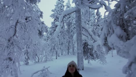 Girl-Exploring-Scenery-In-Snowy-Forest-In-Lapland,-Finland,-Arctic-Circle