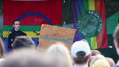 Aktivist-Spricht-Bei-Umweltkundgebung-Mit-„Fridays-For-Future“-Banner,-Publikum-Im-Vordergrund