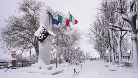 Snow-falling-at-the-entrance-to-the-Garden-of-Villa-Comunale,-Guardiagrele,-Abruzzo,-Italy