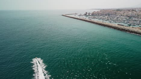 Ein-Jetski-Fährt-Im-Blauen-Wasser-In-Der-Nähe-Von-Puerto-Banus,-Marbella,-Luftaufnahme