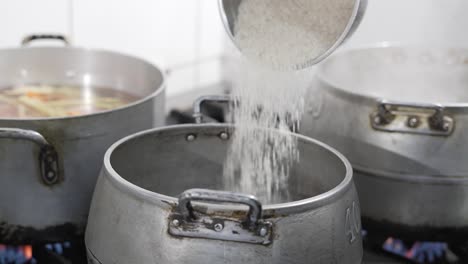 Rice-pouring-into-a-boiling-pot-in-a-bustling-kitchen