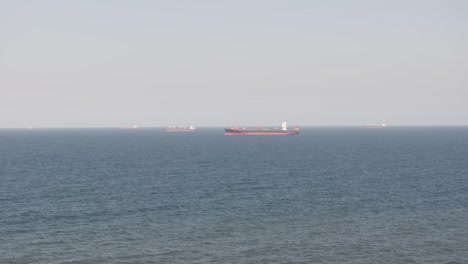 Cargo-ship-sailing-on-the-calm-sea-off-the-coast-of-uMhlanga,-Durban-during-the-day