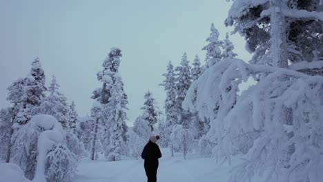 Young-Girl-Explores-Scenery-In-Snowy-Forest-In-Lapland,-Finland,-Arctic-Circle