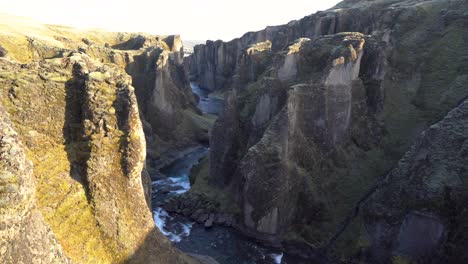 Un-Escarpado-Cañón-Islandés-Con-Un-Río-Que-Fluye-A-Través-De-Acantilados-Cubiertos-De-Musgo