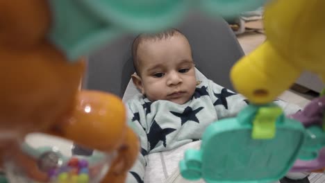 A-charming-scene-of-a-4-month-old-engages-joyfully-in-a-baby-bouncer,-exploring-the-world-of-play-with-delightful-toys