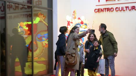 Visitors-take-a-selfie-with-a-dragon-lantern-installation-outside-the-China-Cultural-Centre-to-mark-the-upcoming-Chinese-Lunar-New-Year-2024,-the-Year-of-the-Dragon,-in-Madrid,-Spain