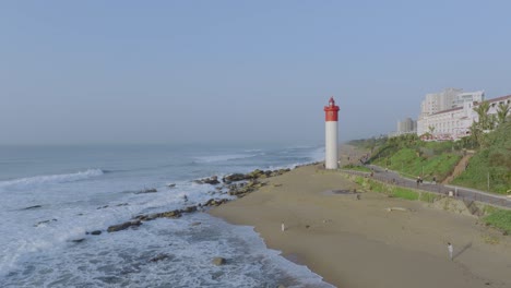 Faro-De-Umhlanga-Y-Costa-Con-Olas-Rompiendo-En-La-Playa,-Durban,-Sudáfrica,-Durante-El-Día,-Vista-Aérea