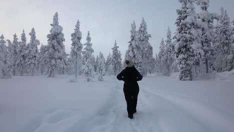 Girl-Exploring-Winter-Scenery-In-Snowy-Forest-In-Lapland,-Finland,-Arctic-Circle