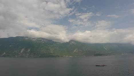 Zeitraffervideo-Mit-Blick-Auf-Den-Gardasee-In-Italien-An-Einem-Bewölkten-Tag-Mit-Sich-Schnell-Bewegenden-Wolken-Und-Vorbeifahrenden-Booten-An-Einem-Bewölkten,-Aber-Sonnigen-Tagesprotokoll