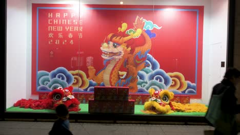 Pedestrians-walk-past-the-China-Cultural-Centre-adorned-with-festive-decorations-in-celebration-of-the-upcoming-Chinese-Lunar-New-Year-2022,-the-Year-of-the-Dragon,-in-Madrid,-Spain
