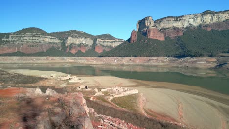 Drone-flight-over-desert-land,-dry-lake-in-Spain-Sau-swamp-dike-in-Catalonia,-Spain,-intense-drought-in-2024