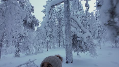 Chica-Explorando-El-Paisaje-Forestal-Cubierto-De-Nieve-En-Laponia,-Finlandia,-El-Círculo-Polar-ártico