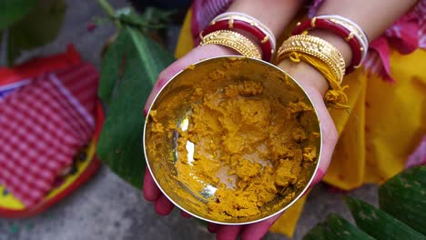 Slow-motion-shot-of-a-Hindu-bride-holding-yellow-turmeric-on-her-hands