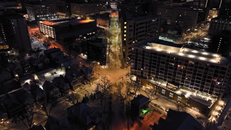 Drone-tilting-over-snowy-streets,-revealing-the-Wisconsin-State-Capitol,-night-in-Madison,-USA