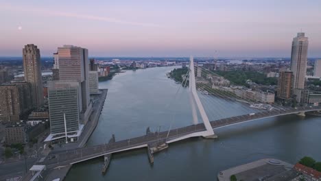 Drone-flight-over-the-Maas-in-Rotterdam-towards-the-Erasmus-Bridge,-morning
