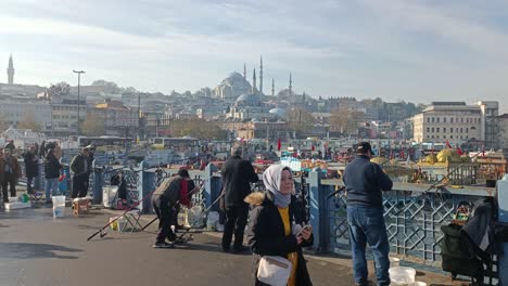 Turkish-locals-fishing-at-Galata-bridge,-ottoman-mosques-in-background,-Istanbul-,Turkey