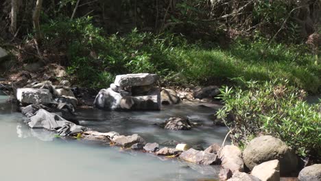 Ein-Kleiner-Damm-Aus-Steinen-Und-Kunststoffmaterial,-Um-Den-Wasserfluss-Eines-Baches-In-Honduras-Zurückzuhalten