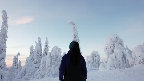 Girl-Admiring-Winter-Wonderland-Landscape-with-Huge-Snow-Covered-Trees-in-Lapland,-Finland,-Arctic-Circle