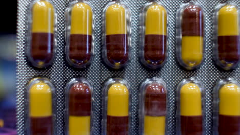 A-close-up-view-of-Amoxicillin-Capsules-as-the-dark-red-and-yellow-components-are-delicately-arranged-into-their-original-packaging,-encapsulates-the-essence-of-medical-care-and-treatment