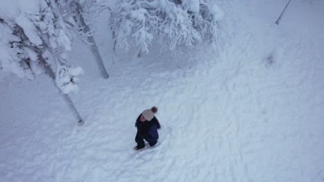 Chica-Mirando-Los-árboles-En-El-País-De-Las-Maravillas-Del-Invierno-Cubierto-De-Nieve-En-Laponia,-Finlandia,-El-Círculo-Polar-ártico