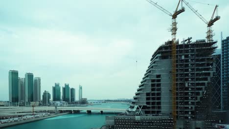 Skyline-Von-Abu-Dhabi,-Vereinigte-Arabische-Emirate-Und-Ein-Bauprojekt---Zeitraffer-Von-Tag-Zu-Nacht