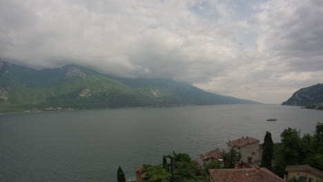 Vídeo-Timelapse-Mirando-El-Lago-De-Garda-En-Italia-En-Un-Día-Nublado-Con-Nubes-Que-Se-Mueven-Rápidamente-Y-Barcos-Pasando-En-Un-Registro-De-Día-Nublado-Pero-Soleado