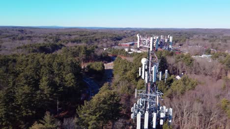 4K-aerial-drone-orbit-around-a-cellular-phone-tower-in-wooded-suburb