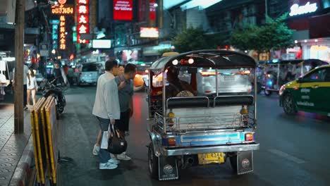 Asiatische-Touristen-Fragen-Tuk-Tuk-Taxifahrer-Nach-Einer-Fahrt-In-Bangkok,-Thailand