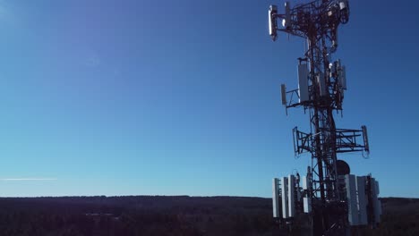 4K-aerial-drone-flyby-a-cell-phone-tower-against-blue-sky