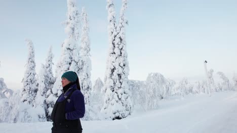 Girl-Walking-Down-Street,-Explores-Beautiful-Snow-Covered-Winter-Wonderland-in-Lapland,-Finland,-Arctic-Circle