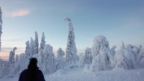 Girl-Admires-Winter-Wonderland-Landscape-with-Huge-Snow-Covered-Trees-in-Lapland,-Finland,-Arctic-Circle