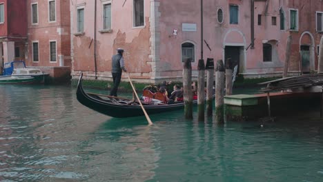Gondolier-steering-on-Venice's-waterway-canal,-Italy