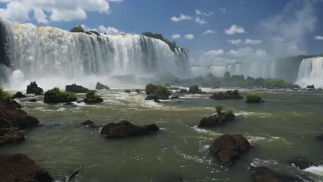 Dramatic-Huge-Waterfalls-Crashing-into-River-Valley-Plunge-Pool,-Beautiful-Rocky-Stream-From-Rough-Crashed-Water-in-Beautiful-Brazil-in-Sunny-Blue-Weather-Conditions-in-Iguazu-Falls,-South-America