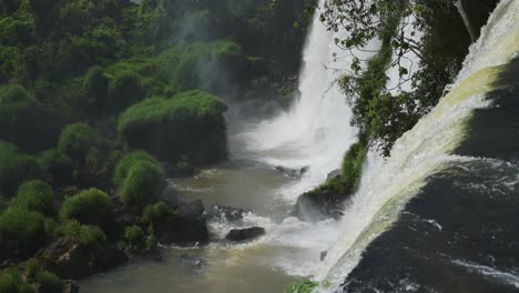 Erstaunlicher-Blick-Aus-Der-Ferne-Auf-Klares,-Wunderschönes-Wasser,-Das-Von-Der-Klippenkante-In-Grüner,-Malerischer-Natur-Strömt,-Tourismusziel-Für-Wunderschöne-Dschungelansichten,-Zeitlupenwasser-In-Den-Iguazu-Wasserfällen