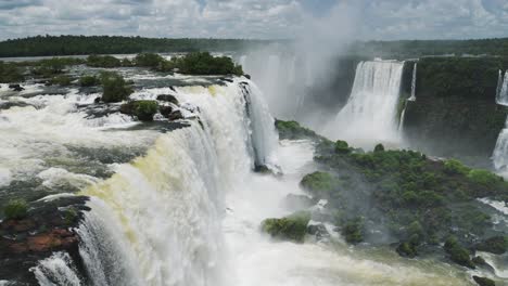 Vista-Muy-Por-Encima-De-Una-Gran-Cascada-Que-Cae-En-Una-Piscina-De-Inmersión-En-La-Selva-Tropical-En-Un-Colorido-Paisaje-De-Selva-Verde,-Hermosa-Caída-De-Agua-Clara-En-Las-Cataratas-Del-Iguazú,-Brasil,-América-Del-Sur