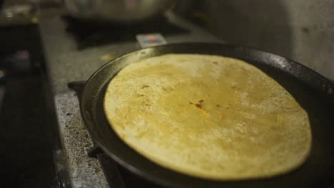 Hände-Drehen-Einen-Traditionellen-Pakistanischen-Pfannkuchen-In-Einer-Pfanne-Auf-Einem-Herd