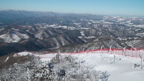 Majestätisches-Winterpanorama-Des-Gangwon-do-Gebirges-Und-Menschen,-Die-Die-Balwangsan-Berghänge-Im-Yong-Pyong-Skigebiet-Pyeongchang-Gun-Hinunterfahren-–-Zeitlupenschwenk