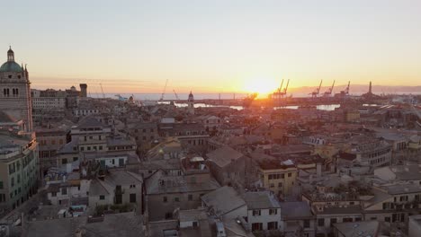 Sunset-over-Genoa's-historic-skyline-with-prominent-architecture-and-port-cranes,-warm-glow