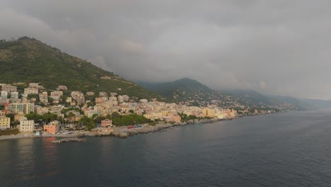 Aerial-shot-of-Genoa-coastline-with-buildings-and-moody-sky,-evening-light