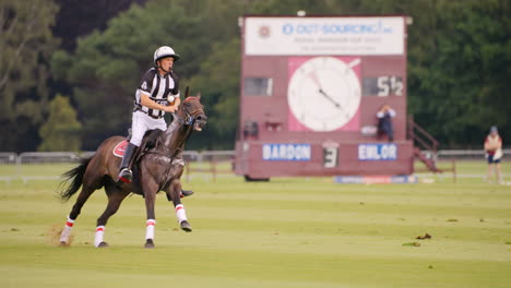 Polo-referee-canters-up-a-the-field-riding-a-sweaty-horse-with-a-whistle-in-his-mouth