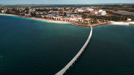 drone-shot-over-the-Esperance-Jetty-and-the-city-esplanade-on-a-sunny-day-with-some-clouds,-Western-Australia