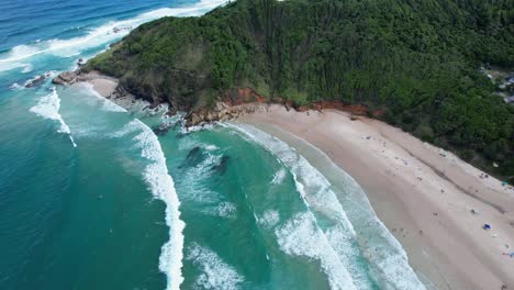 Ocean-Waves-Splashing-On-Sandy-Shore-Of-Broken-Head-Beach-In-New-South-Wales,-Australia---Aerial-Drone-Shot