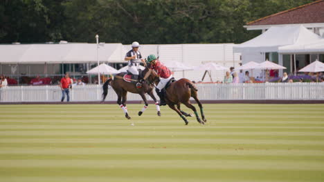 Polo-referee-rides-past-a-player-hitting-the-ball-with-a-backswing