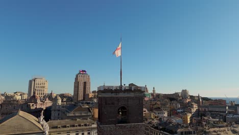 Clear-blue-sky-over-Genoa's-historic-center-with-a-fluttering-flag,-capturing-the-essence-of-Italian-heritage