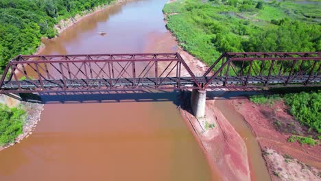 Aerial-footage-flying-over-a-train-bridge-on-the-Red-River-in-Texas