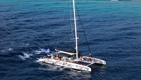 Aerial-overview-of-Catamaran-driving-along-deep-blue-Caribbean-coastal-waters